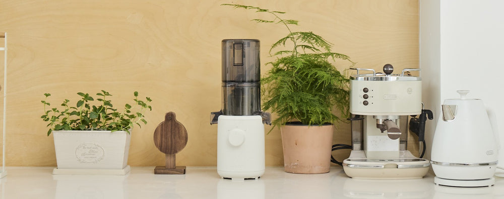 White espresso machine with potted plants on a beige wall background H310A