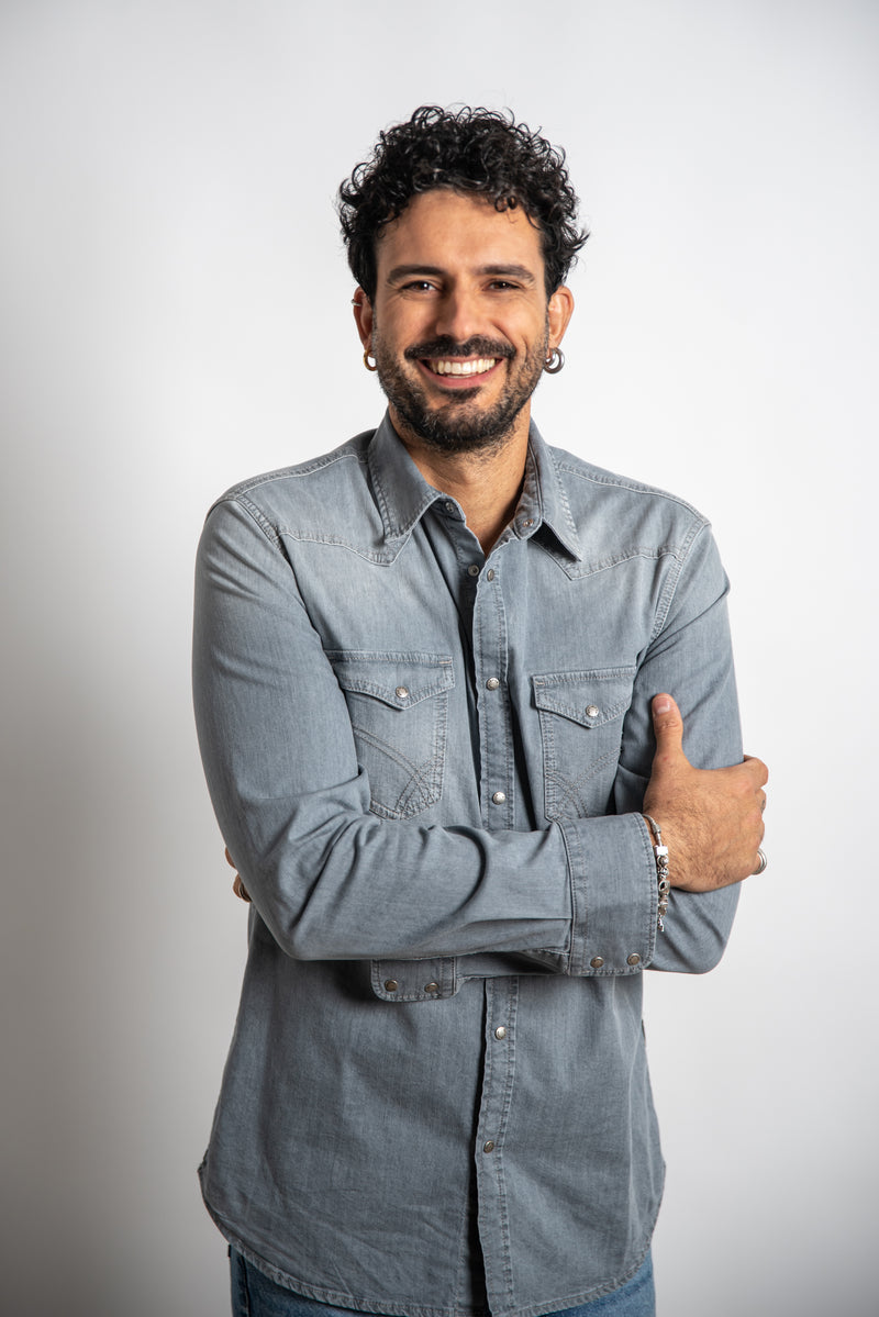 Man wearing a denim shirt on a plain background