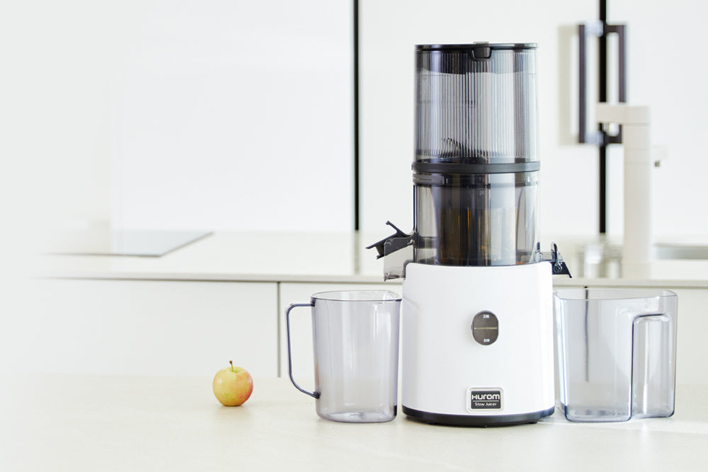 White juicer with clear container on a white countertop H330P