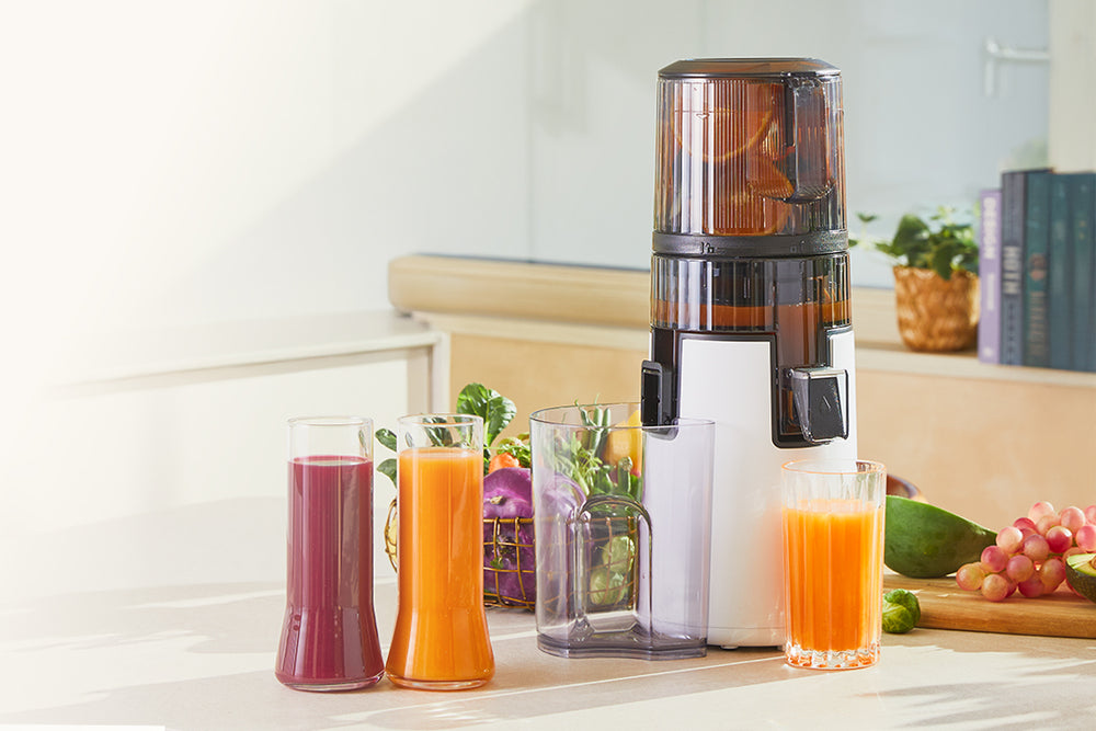 Juicer with glasses of juice on a kitchen counter H70ST
