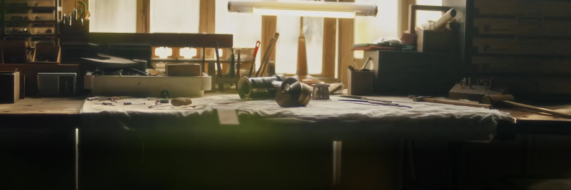 A nostalgic workshop scene featuring an engineer's workbench covered with technical blueprints, metal tools, and juicer components under warm lighting. The text "Our Story" is displayed in the bottom left, symbolizing Hurom's heritage and craftsmanship.